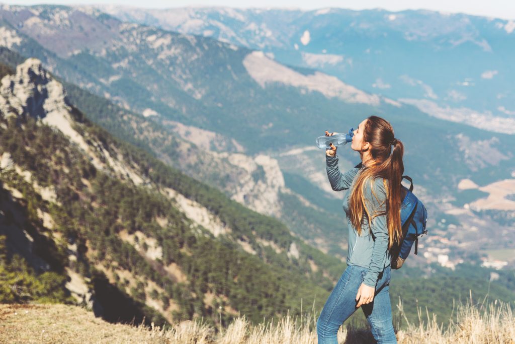 Persona bebiendo en la montaña